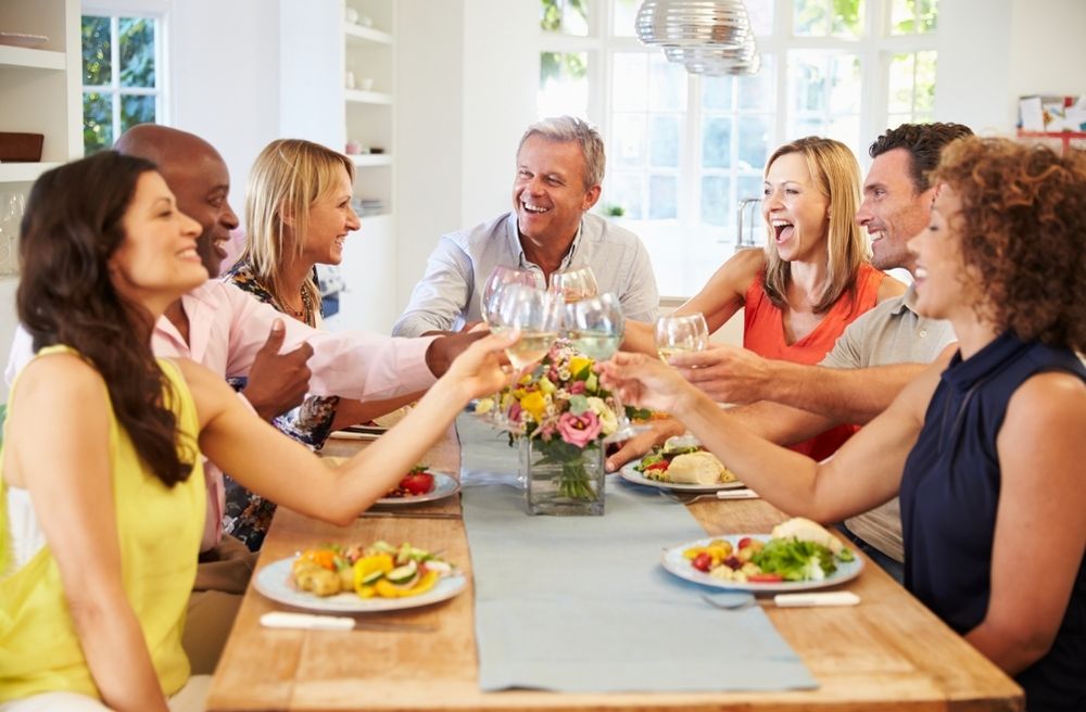 Friends laughing around dinner table