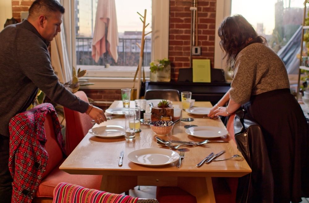 Guests at Dinner Party Setting Table