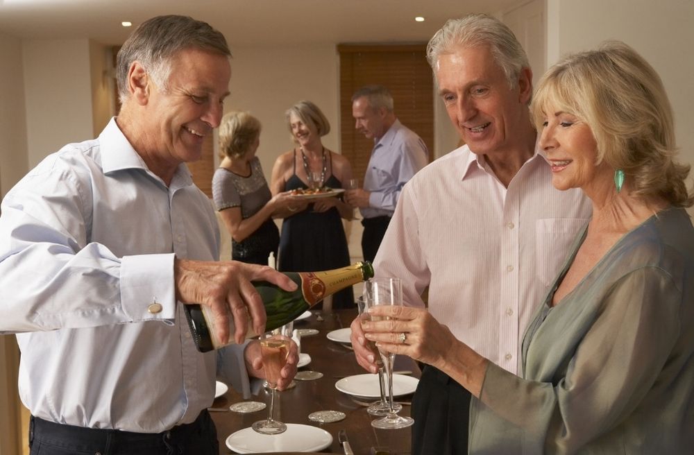 Man Serving Champagne to His Guests at a Dinner Party