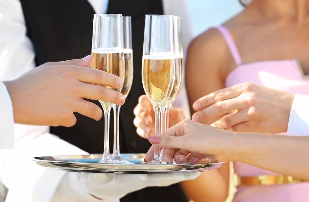 host offering drink to guest