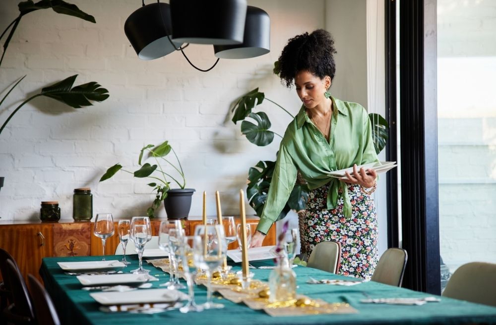 host preparing dining room before dinner party