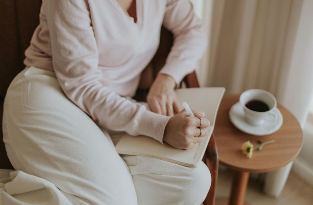 woman writing journal at kitchen table