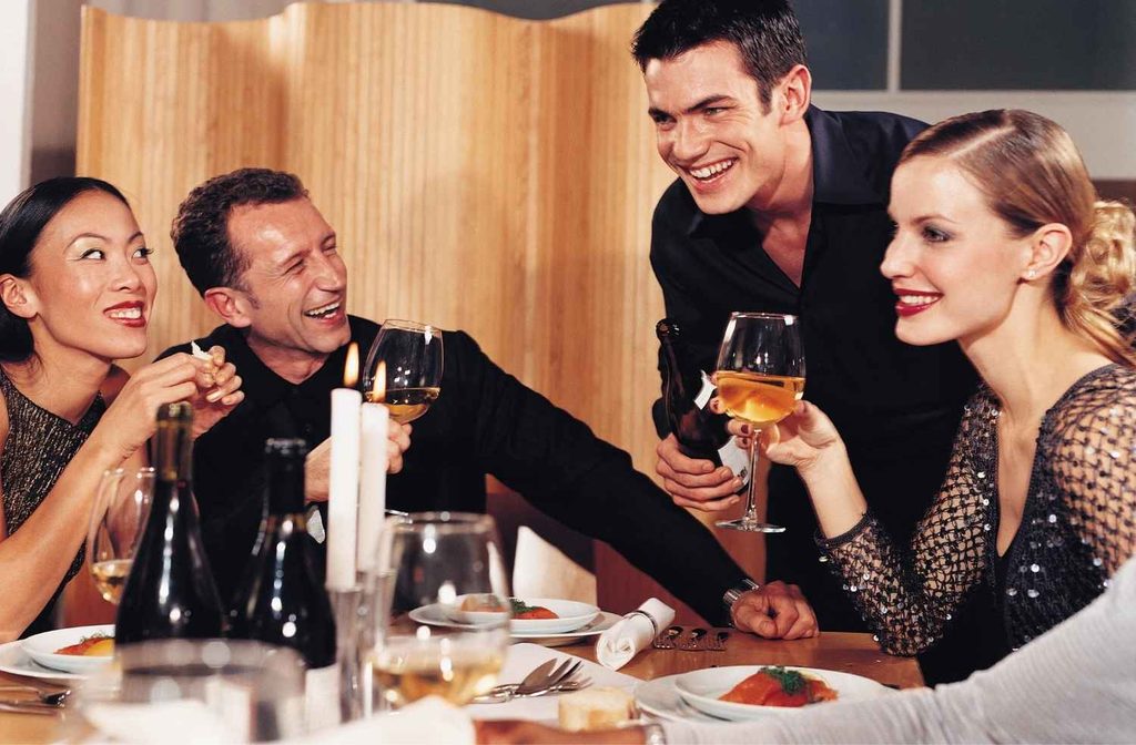 host talking to dinner guests