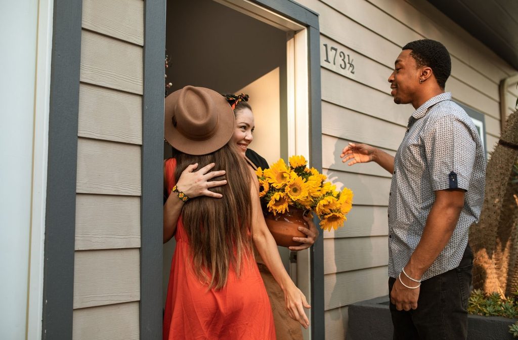 host welcoming guest at front door