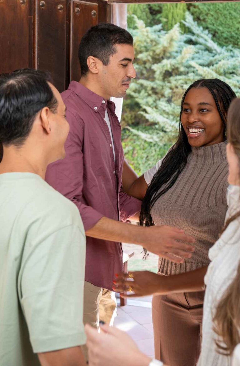 host welcoming guests at front door