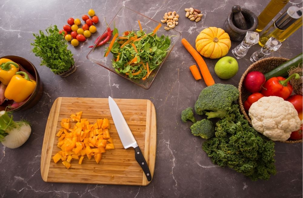 A tidy kitchen with prepared ingredients, chopped vegetables being prepared ahead of a dinner party