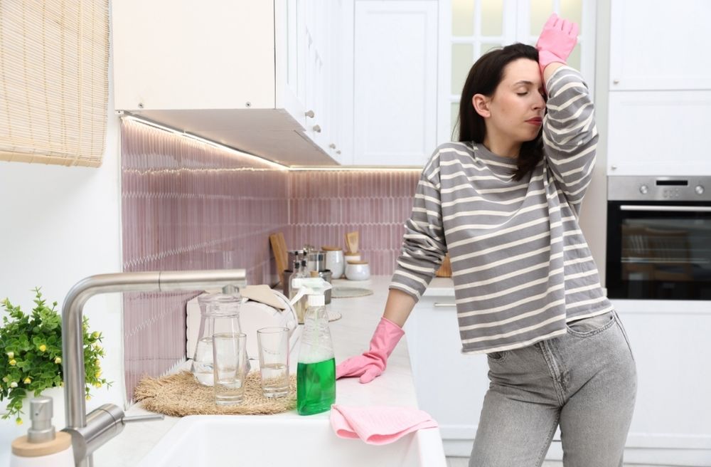 tired host cleaning kitchen